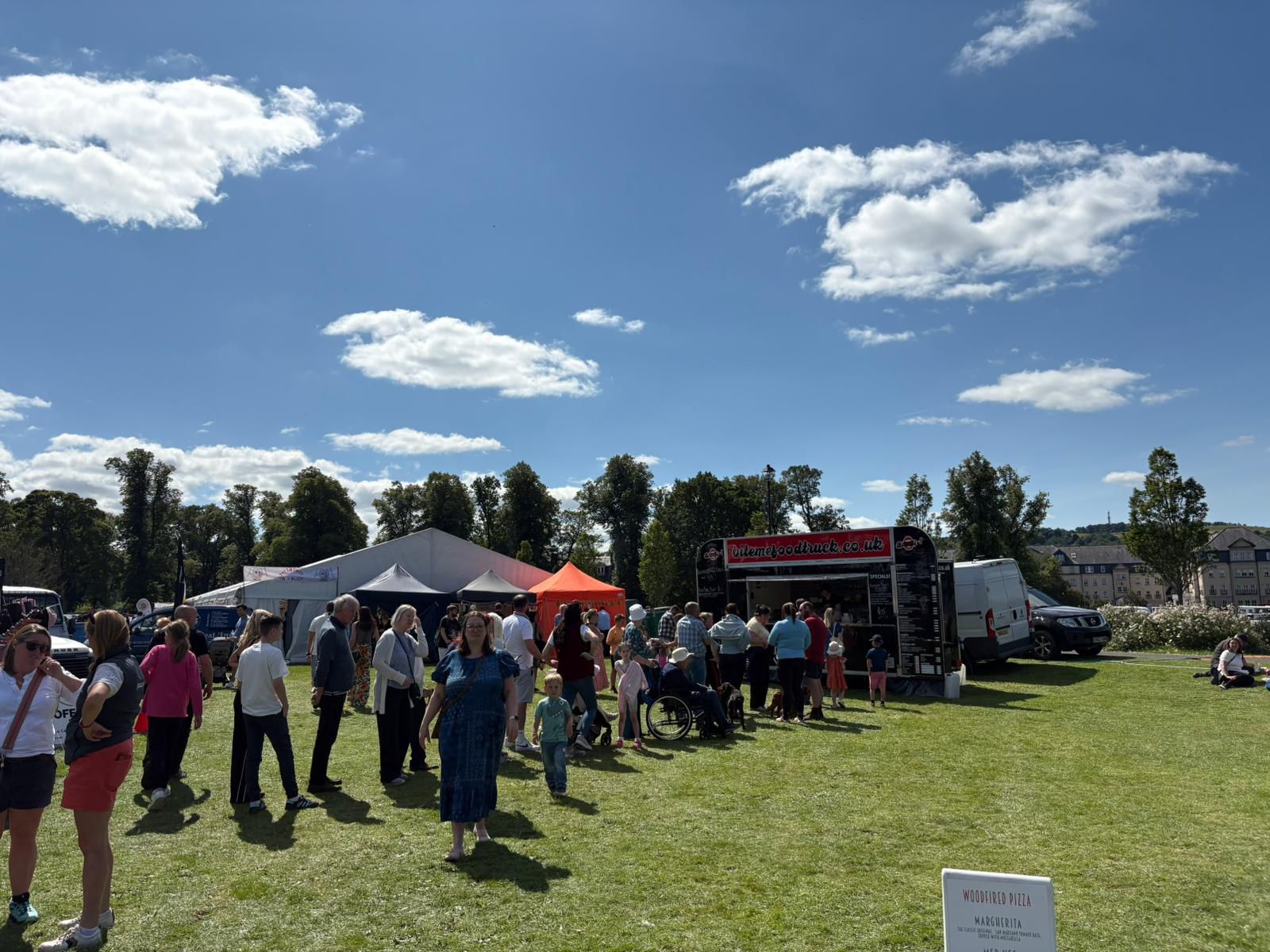 Busy festival with food traders serving crowds on a sunny day