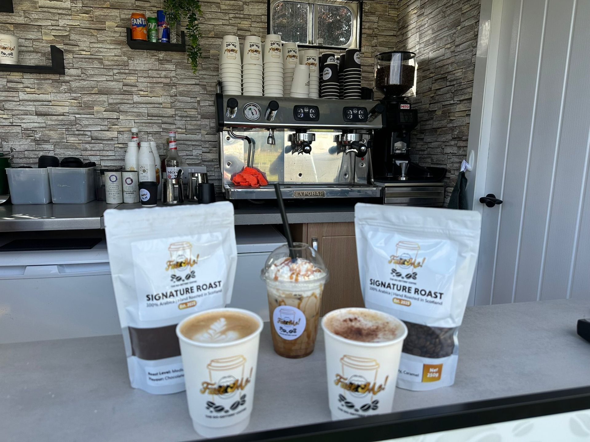 Specialty coffee drinks and Signature Roast bags at Fuel Me counter